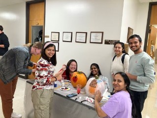 Graduate students painting pumpkins